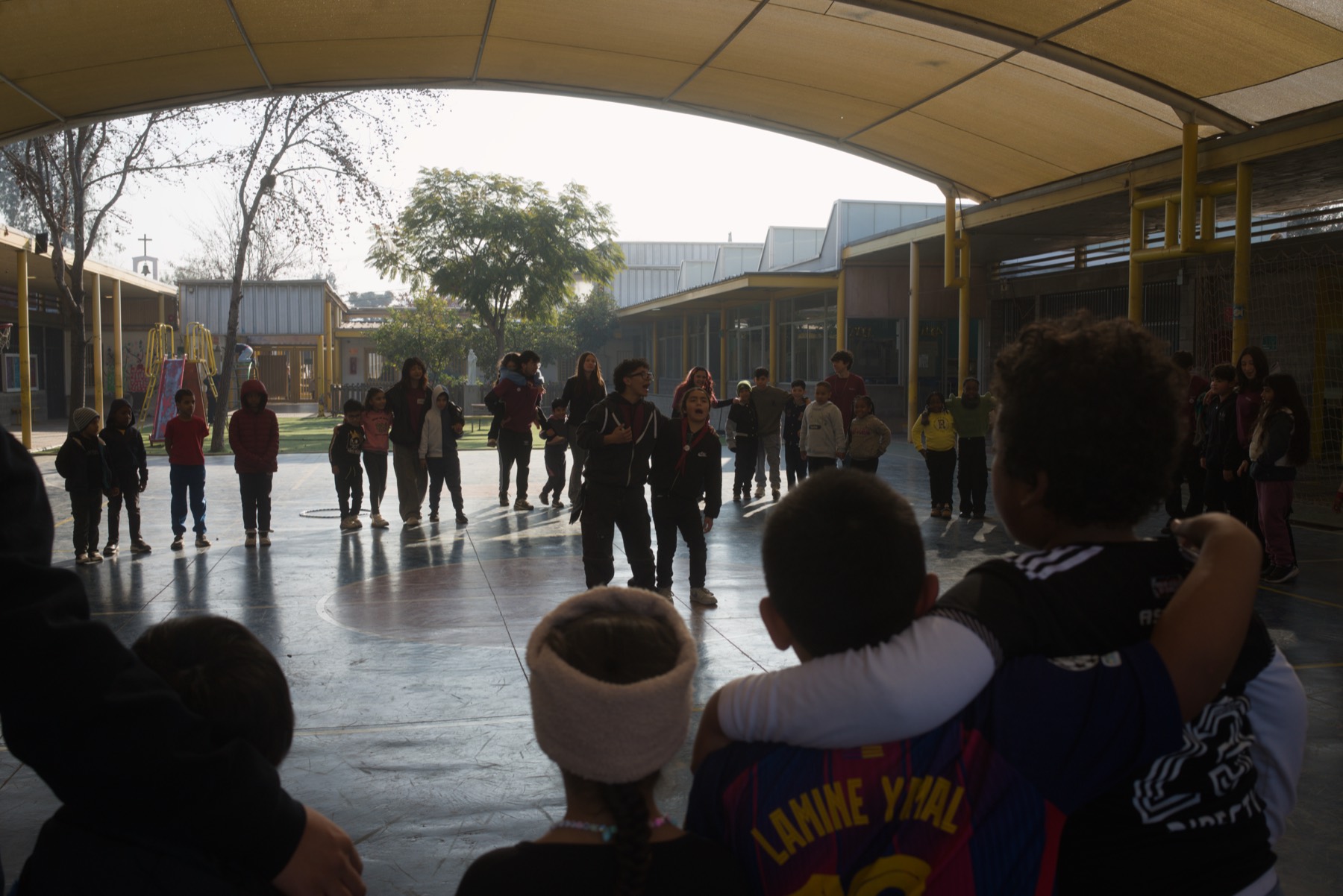 Niños y monitores en círculo en el patio del colegio