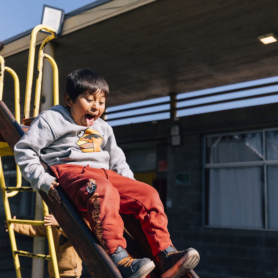 Niño bajando por el resbalín