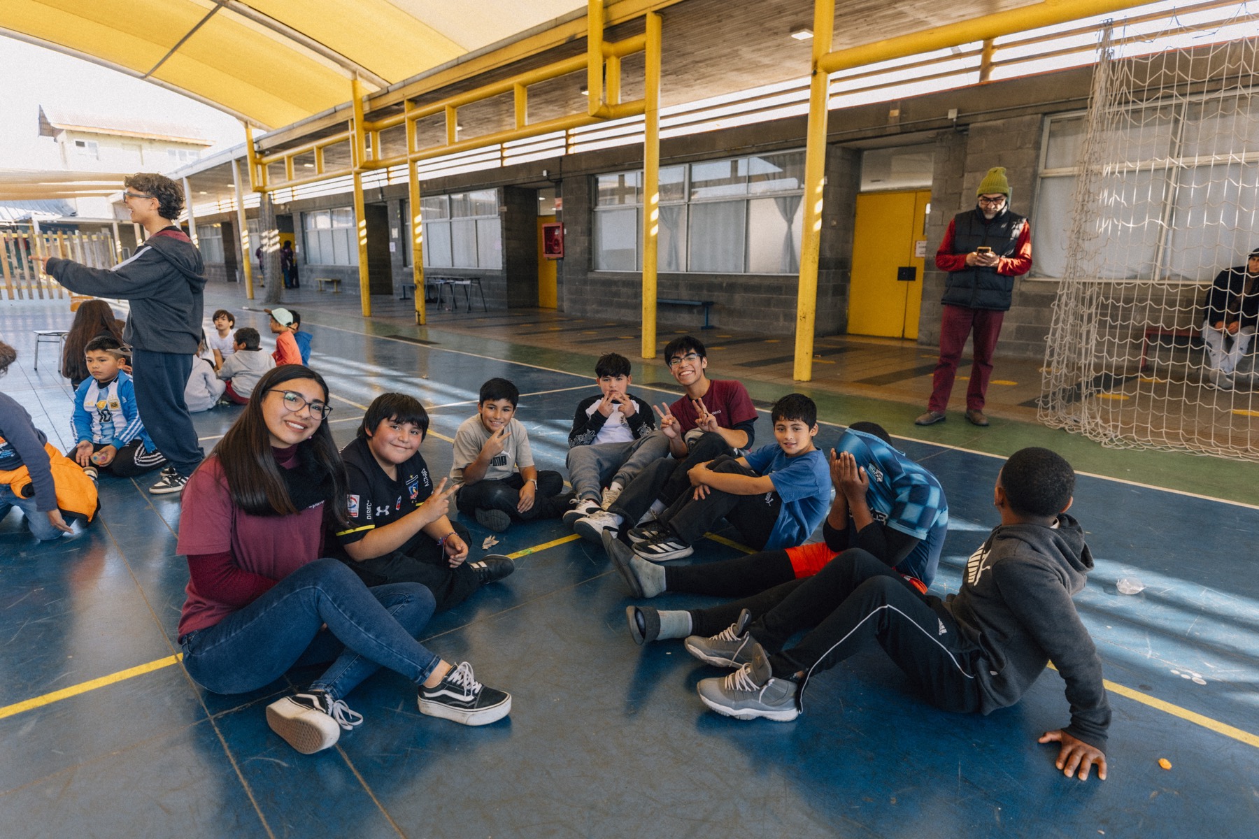 Niños y monitores sentados en círculo en el patio