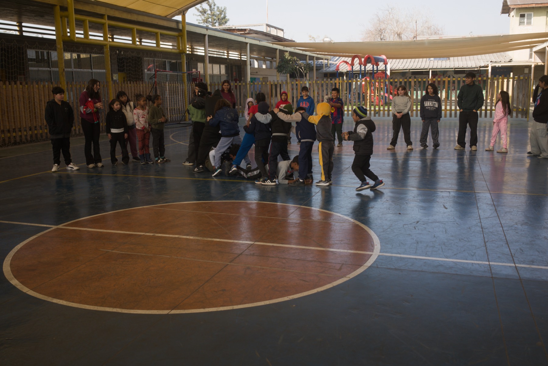 Niños y monitores jugando en la cancha durante las Colonias Urbanas