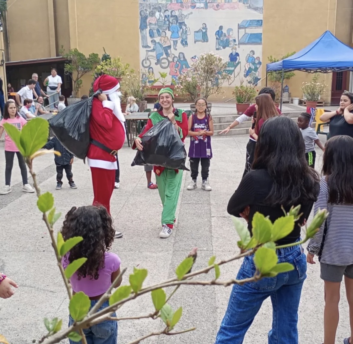 Viejito pascuero repartiendo juguetes en la fiesta navideña