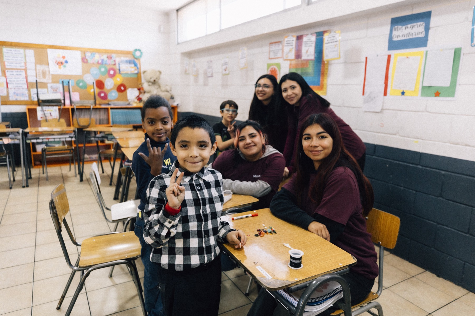 Monitoras y niños de la población en el taller de bisutería durante las Colonias Urbanas