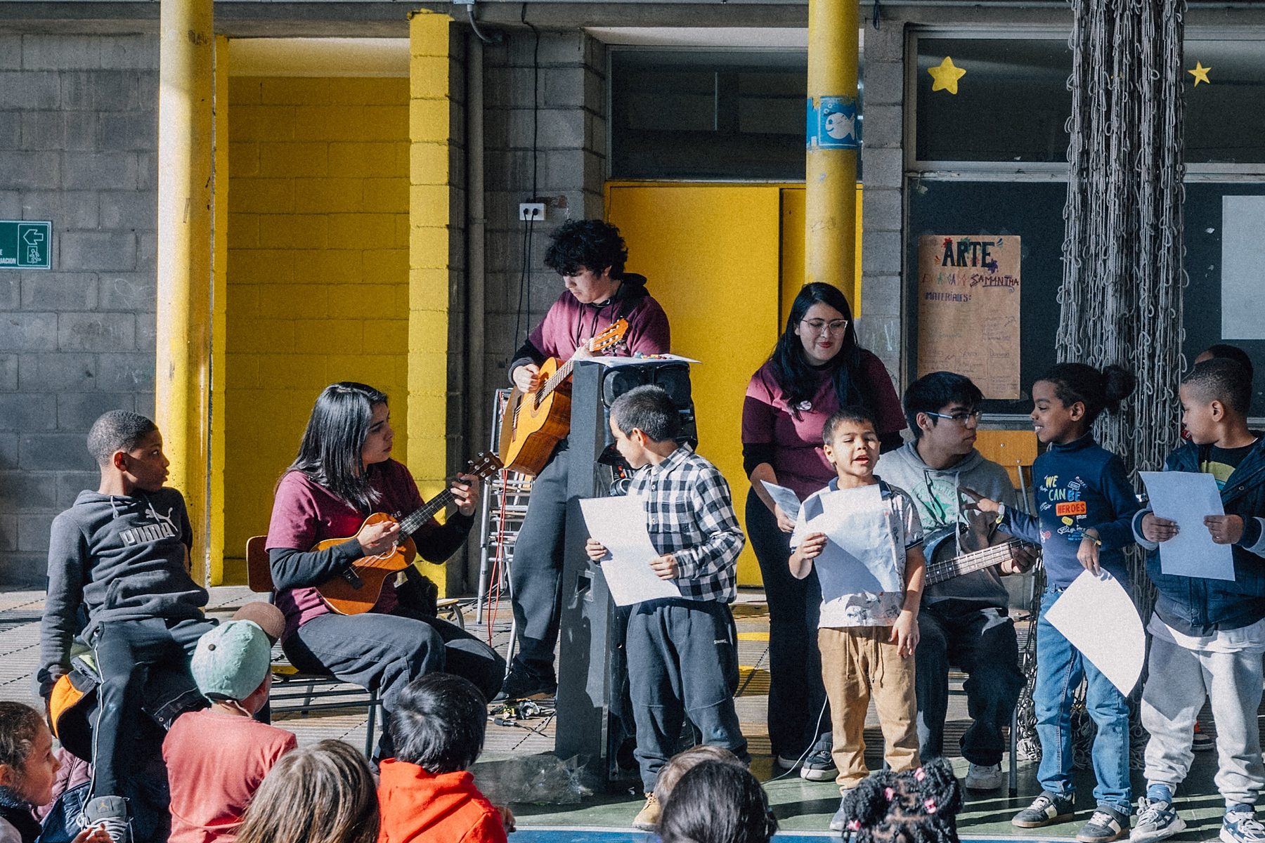 Taller de música: monitores con guitarras y niños cantando